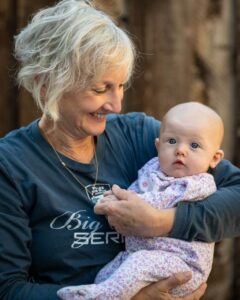 Carol holding baby granddaughter, Kepi