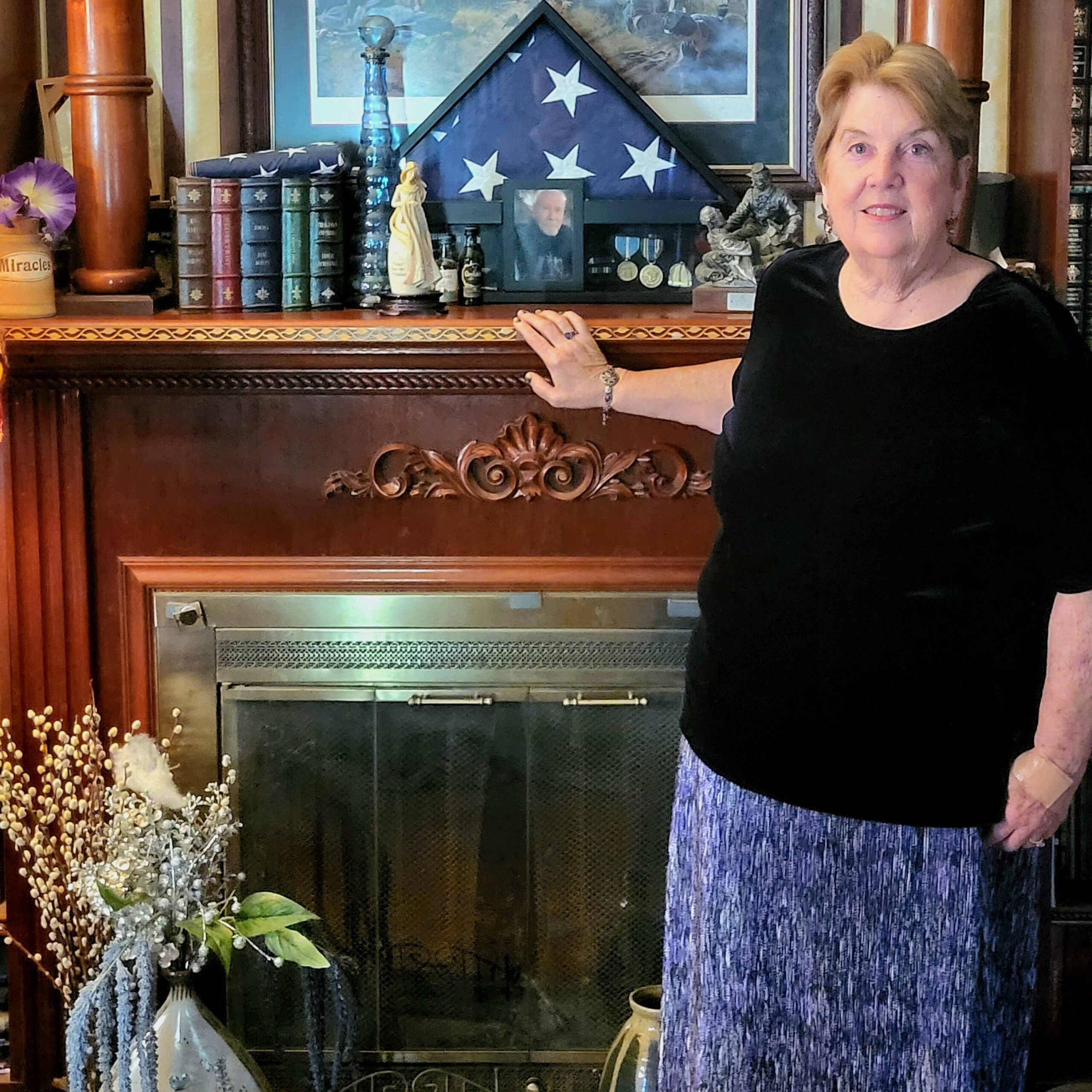 Ruth standing by Fireplace facade