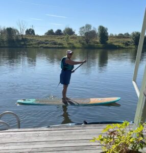 Sylvia paddleboarding off her front deck