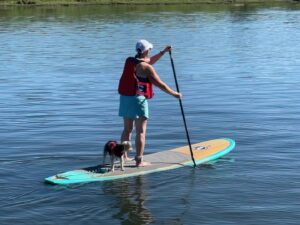 Sylvia paddleboarding with The Biscuit, her constant companion